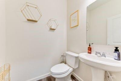 bathroom with sink, hardwood / wood-style flooring, and toilet