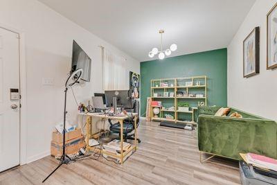 office space featuring a chandelier and light hardwood / wood-style floors