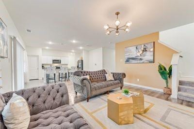 living room featuring a chandelier and light wood-type flooring