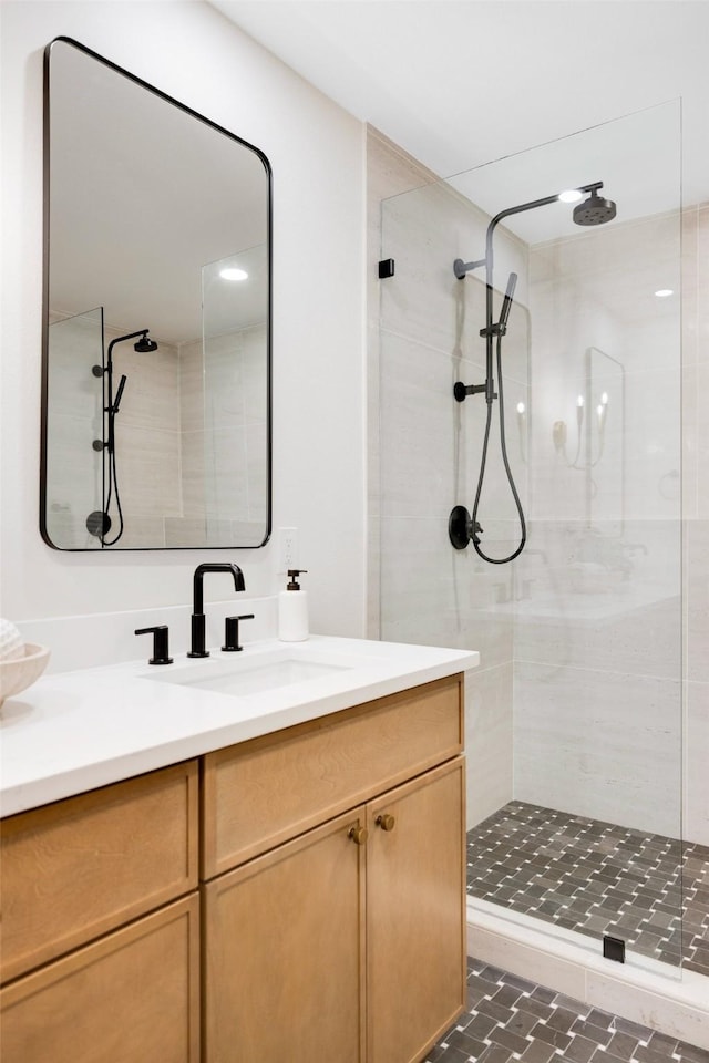 bathroom featuring tiled shower, vanity, and tile patterned floors