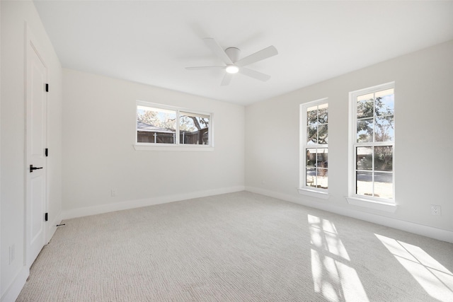 carpeted spare room featuring plenty of natural light and ceiling fan