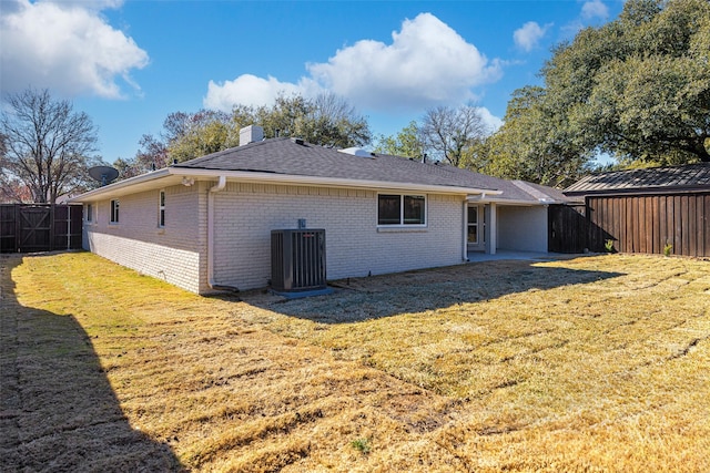 back of house with a yard and central AC unit