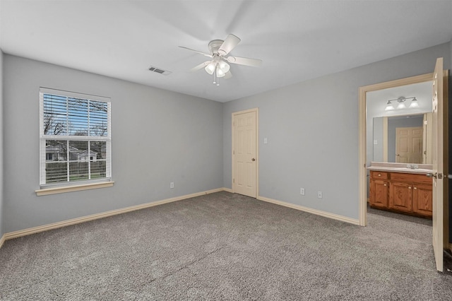 unfurnished bedroom featuring sink, ensuite bath, carpet floors, and ceiling fan