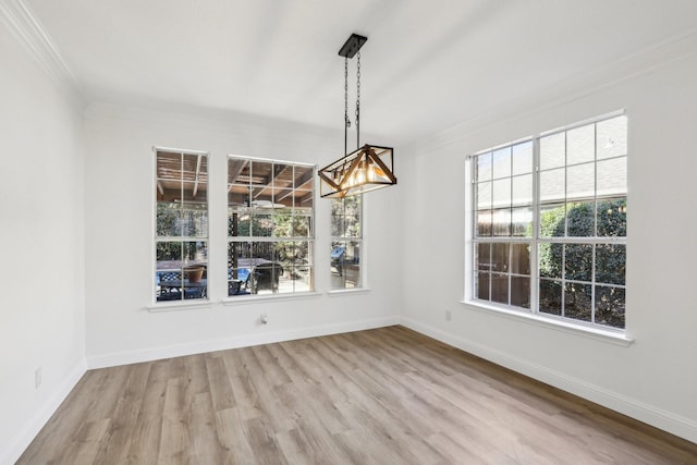 unfurnished dining area featuring ornamental molding and light hardwood / wood-style flooring