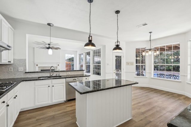 kitchen featuring sink, stainless steel appliances, decorative backsplash, white cabinets, and decorative light fixtures