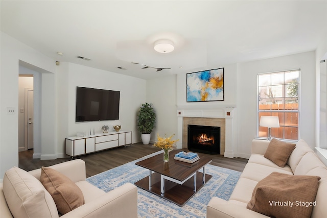 living room featuring dark hardwood / wood-style flooring and a tile fireplace