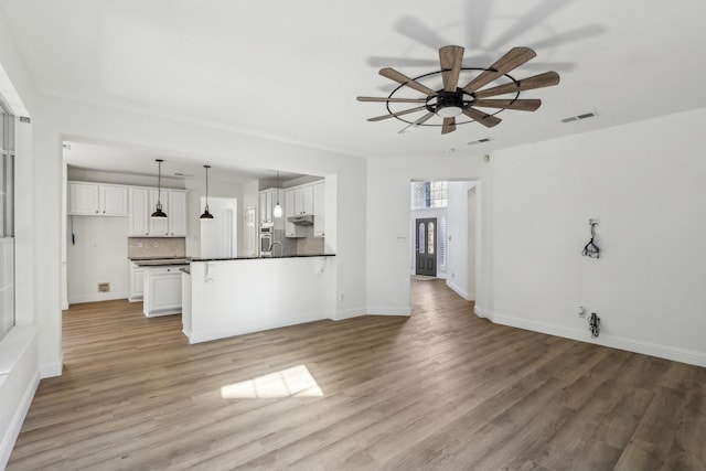 unfurnished living room with ceiling fan and light hardwood / wood-style flooring