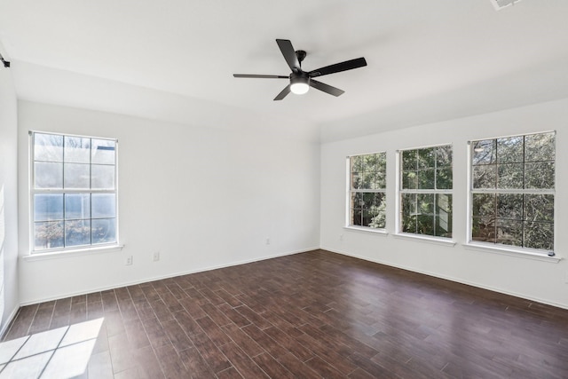 spare room with ceiling fan, a healthy amount of sunlight, and dark hardwood / wood-style floors