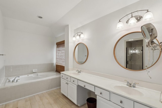 bathroom featuring vanity, tiled bath, and hardwood / wood-style floors