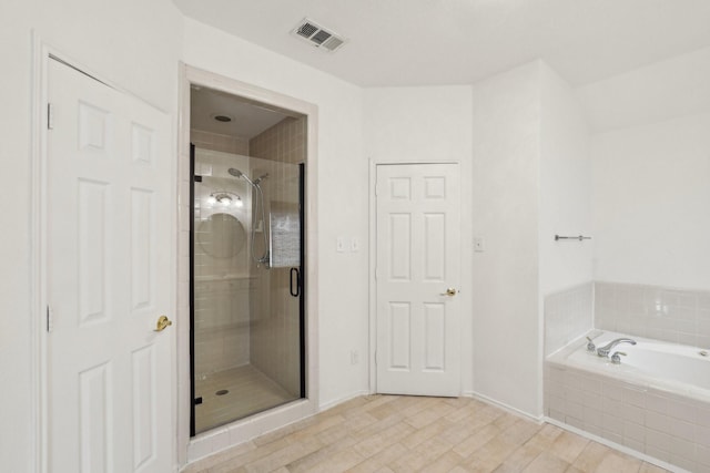 bathroom featuring wood-type flooring and plus walk in shower