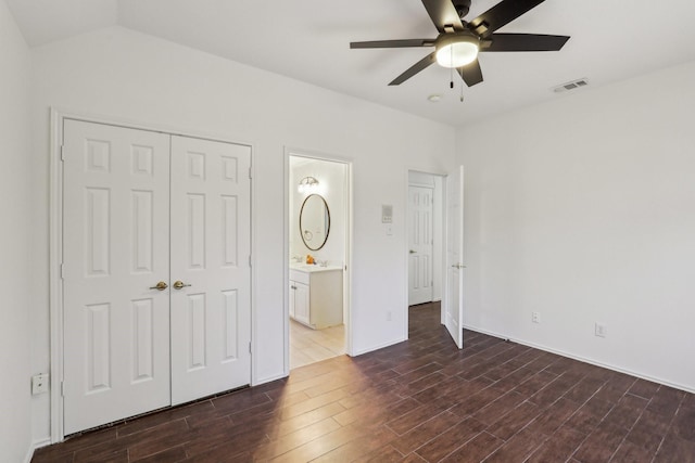 unfurnished bedroom featuring ceiling fan, ensuite bathroom, and a closet