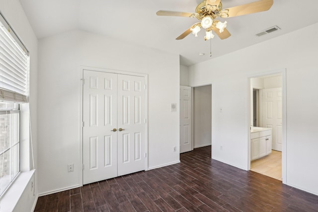 unfurnished bedroom with ceiling fan, ensuite bathroom, and a closet