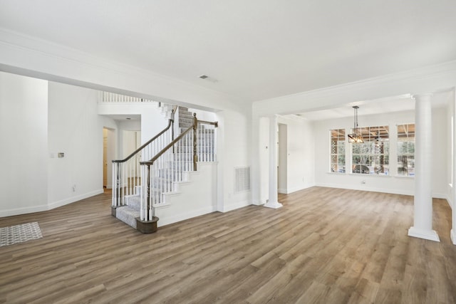 unfurnished living room featuring hardwood / wood-style flooring, ornamental molding, and decorative columns