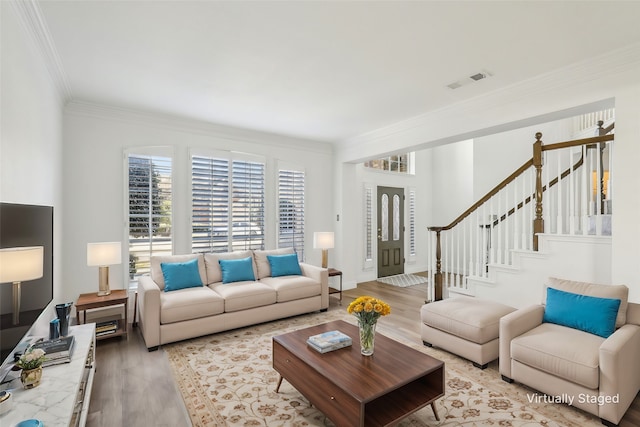 living room with ornamental molding and light hardwood / wood-style flooring