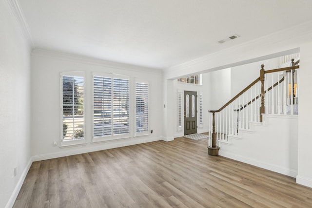 foyer with ornamental molding and light hardwood / wood-style flooring