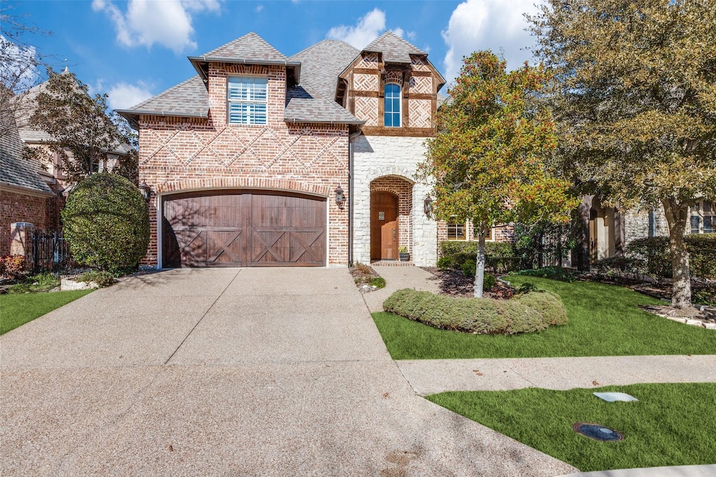 view of front of property with a garage and a front lawn