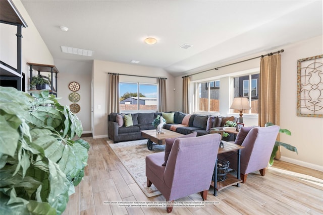 living room featuring lofted ceiling and light hardwood / wood-style floors