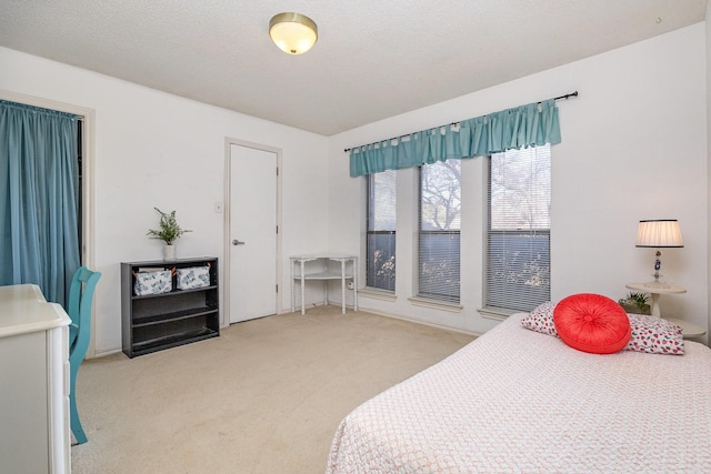 bedroom featuring light colored carpet and a textured ceiling