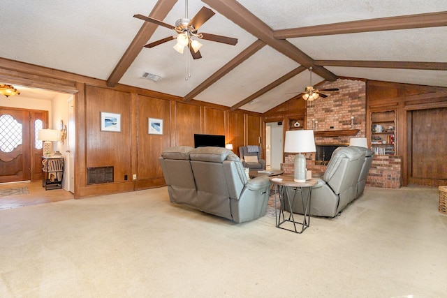 carpeted living room featuring vaulted ceiling with beams, wood walls, a textured ceiling, ceiling fan, and a fireplace