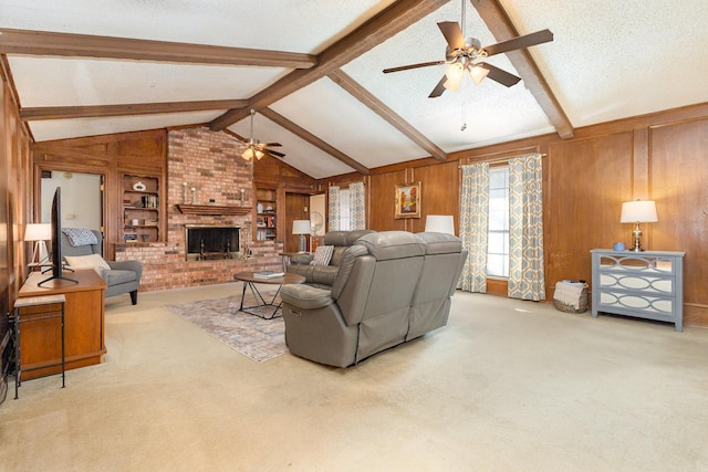 carpeted living room with wooden walls, vaulted ceiling with beams, ceiling fan, a brick fireplace, and a textured ceiling