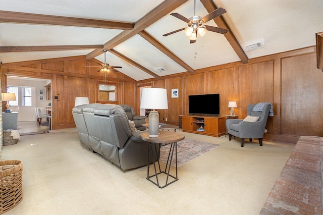 living room with ceiling fan, wooden walls, lofted ceiling with beams, and light carpet