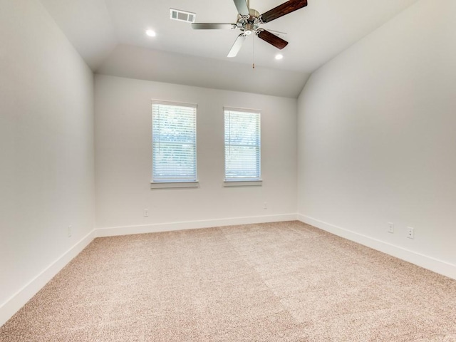 spare room featuring vaulted ceiling, ceiling fan, and carpet