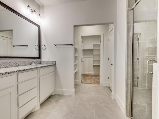 bathroom with tile patterned flooring, vanity, and an enclosed shower