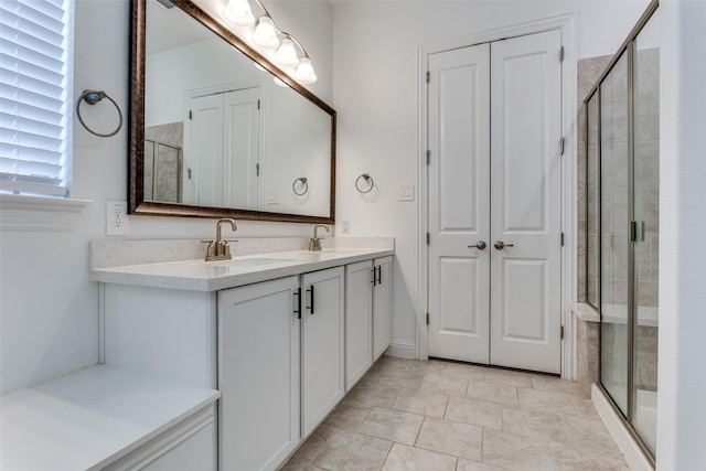 bathroom with tile patterned floors, vanity, and a shower with door