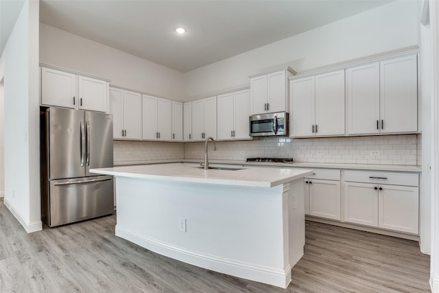 kitchen featuring white cabinetry, appliances with stainless steel finishes, sink, and a kitchen island with sink