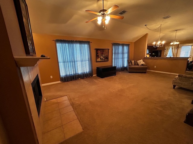 living room with lofted ceiling, ceiling fan with notable chandelier, and carpet floors