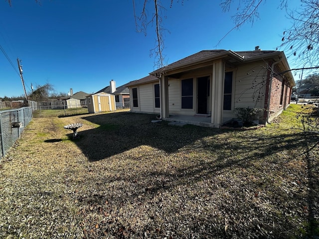 back of property with a shed and a lawn