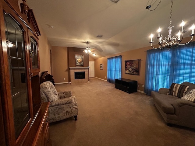 living room featuring vaulted ceiling, carpet floors, ceiling fan with notable chandelier, and a fireplace