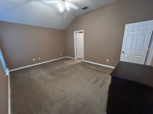 interior space featuring ceiling fan, carpet flooring, vaulted ceiling, and a textured ceiling