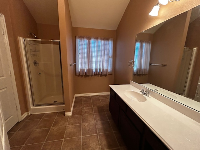 bathroom featuring vaulted ceiling, vanity, tile patterned floors, and walk in shower