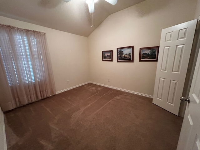 unfurnished room with lofted ceiling and dark carpet