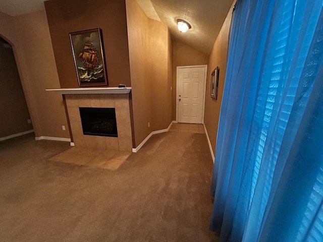 corridor featuring carpet floors, a textured ceiling, and vaulted ceiling