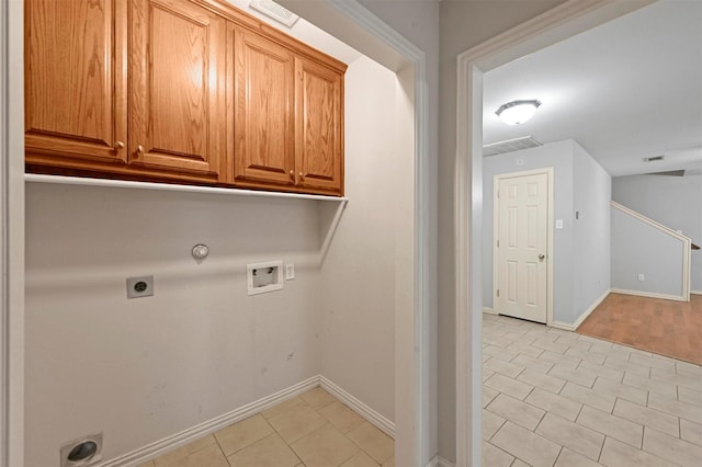 clothes washing area with light tile patterned floors, electric dryer hookup, hookup for a washing machine, cabinets, and hookup for a gas dryer