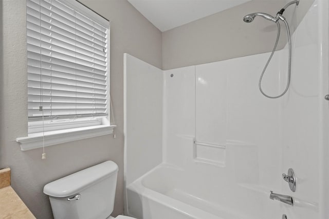 bathroom featuring shower / bathtub combination and toilet