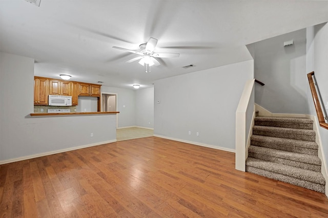 unfurnished living room with ceiling fan and light hardwood / wood-style floors