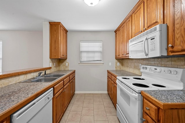 kitchen featuring white appliances, light tile patterned floors, sink, and backsplash