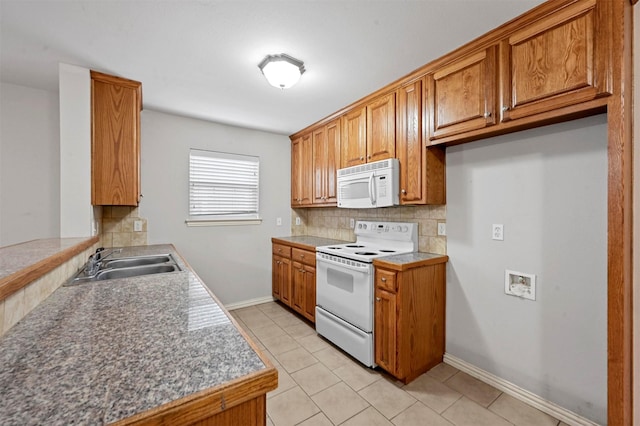 kitchen featuring light tile patterned flooring, sink, backsplash, and white appliances