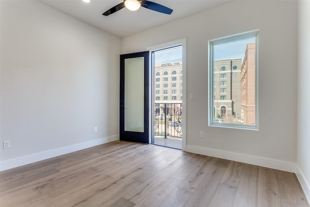 empty room featuring baseboards, light wood finished floors, and ceiling fan