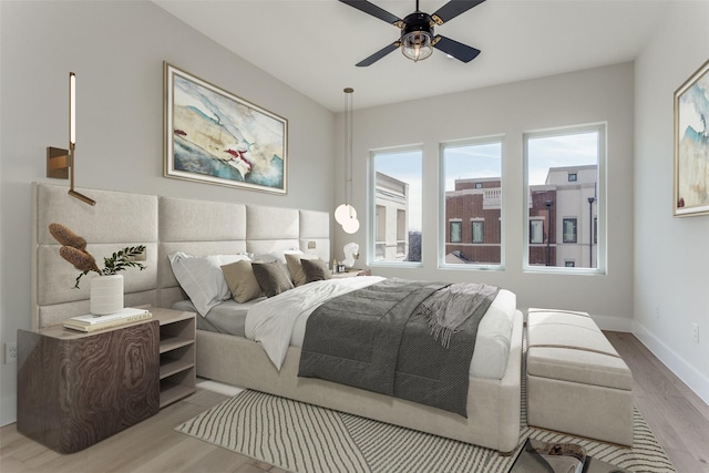 bedroom with wood finished floors, baseboards, and ceiling fan