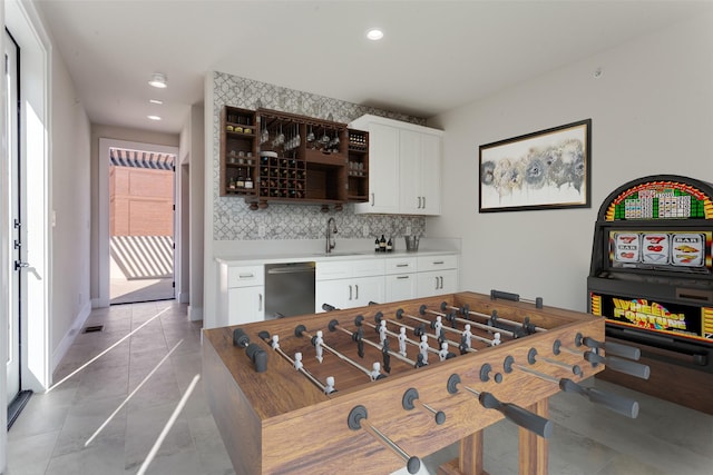 game room with recessed lighting, baseboards, and a sink