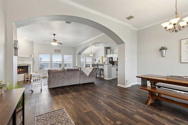 living room featuring crown molding, ceiling fan with notable chandelier, and dark wood-type flooring