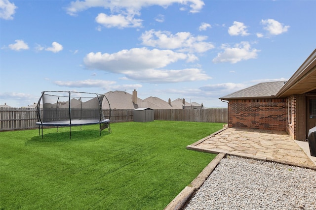 view of yard featuring a trampoline, a storage shed, and a patio