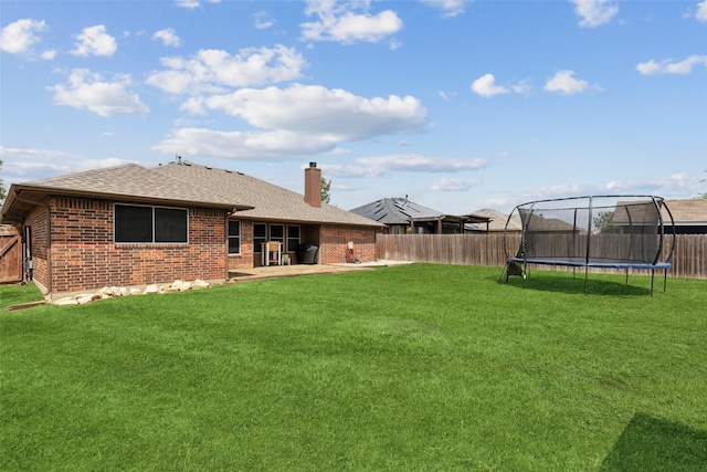 view of yard featuring a trampoline and a patio area