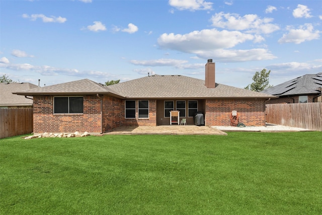 back of property with a yard and a patio area