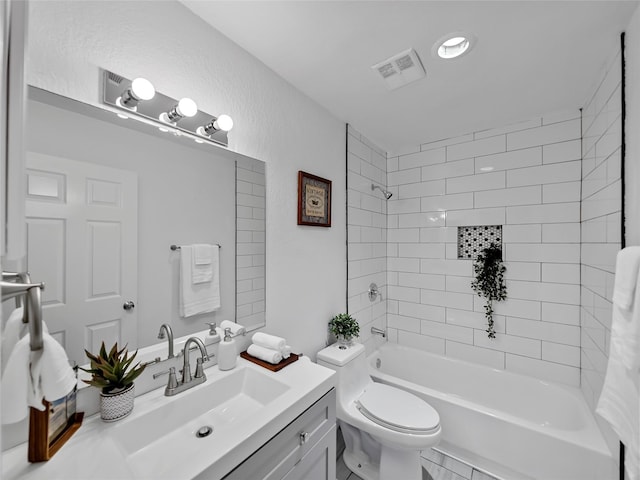 full bathroom with vanity, toilet, and tiled shower / bath