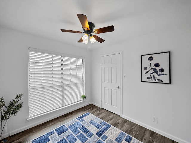 spare room featuring dark wood-type flooring and ceiling fan